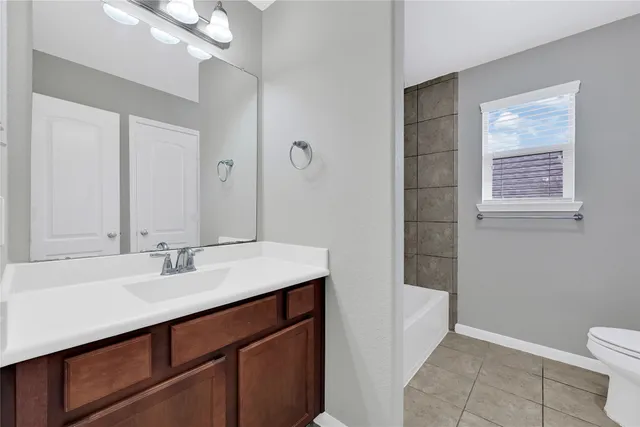 a bathroom with a sink a toilet and a mirror