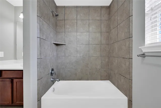 a bathroom with a white bath tub and a shower