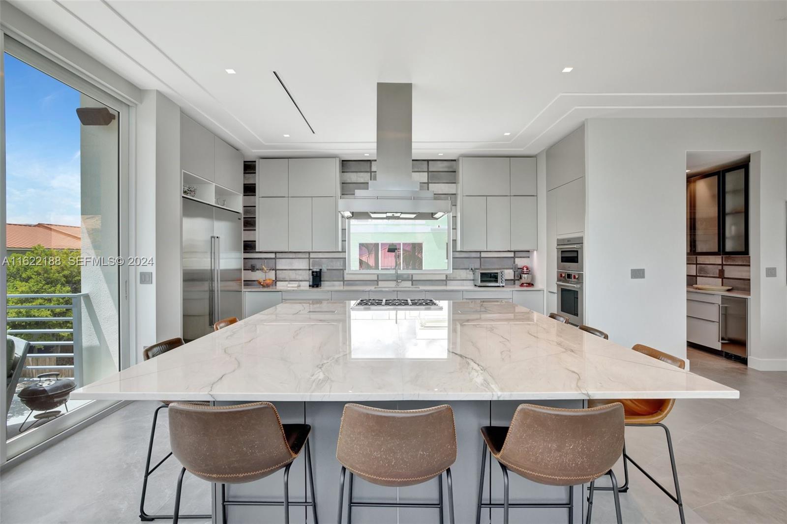 305 Oak Street Hollywood, FL 33019 - Photo 45 of 97 a kitchen with stainless steel appliances kitchen island granite countertop a kitchen island and chairs in it