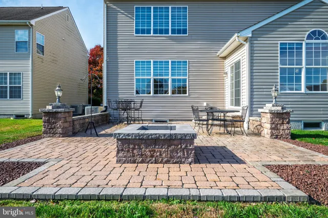 a view of house with backyard and sitting area