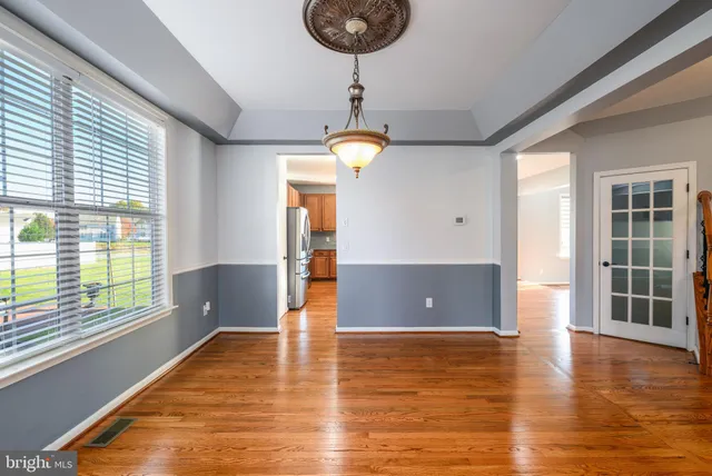 a view of empty room with wooden floor and large window