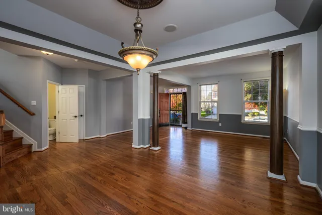 a view of a hallway with wooden floor and a chandelier