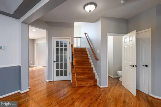 a view of a hallway with wooden floor and stairs