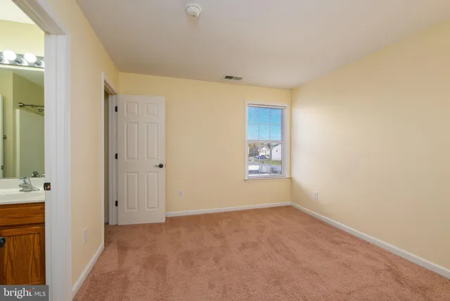 an empty room with closet and a bathroom