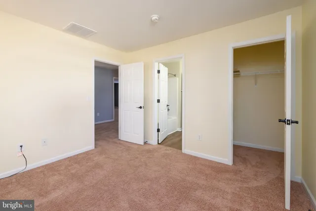 a spacious bathroom with a double vanity sink a toilet and a mirror