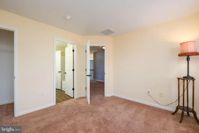 a view of an empty room with windows and closet