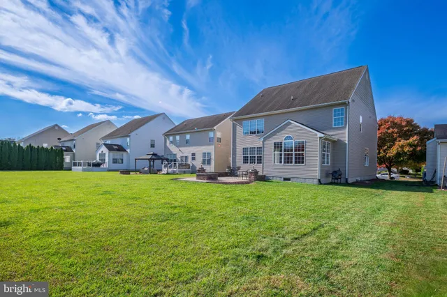 a view of a chair and table in backyard of the house