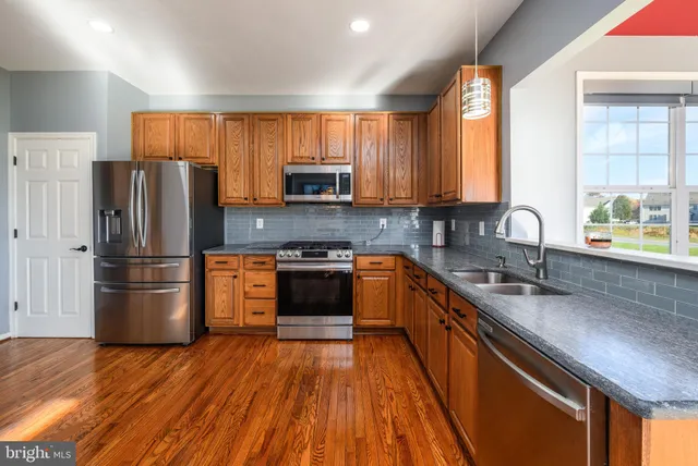 a kitchen with stainless steel appliances a refrigerator sink and microwave