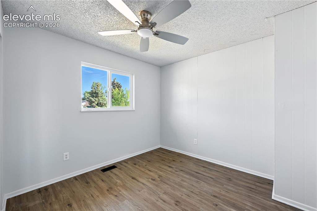 7033 Sequoyah Way Colorado Springs, CO 80915 - Photo 12 of 20 an empty room with wooden floor and ceiling fan