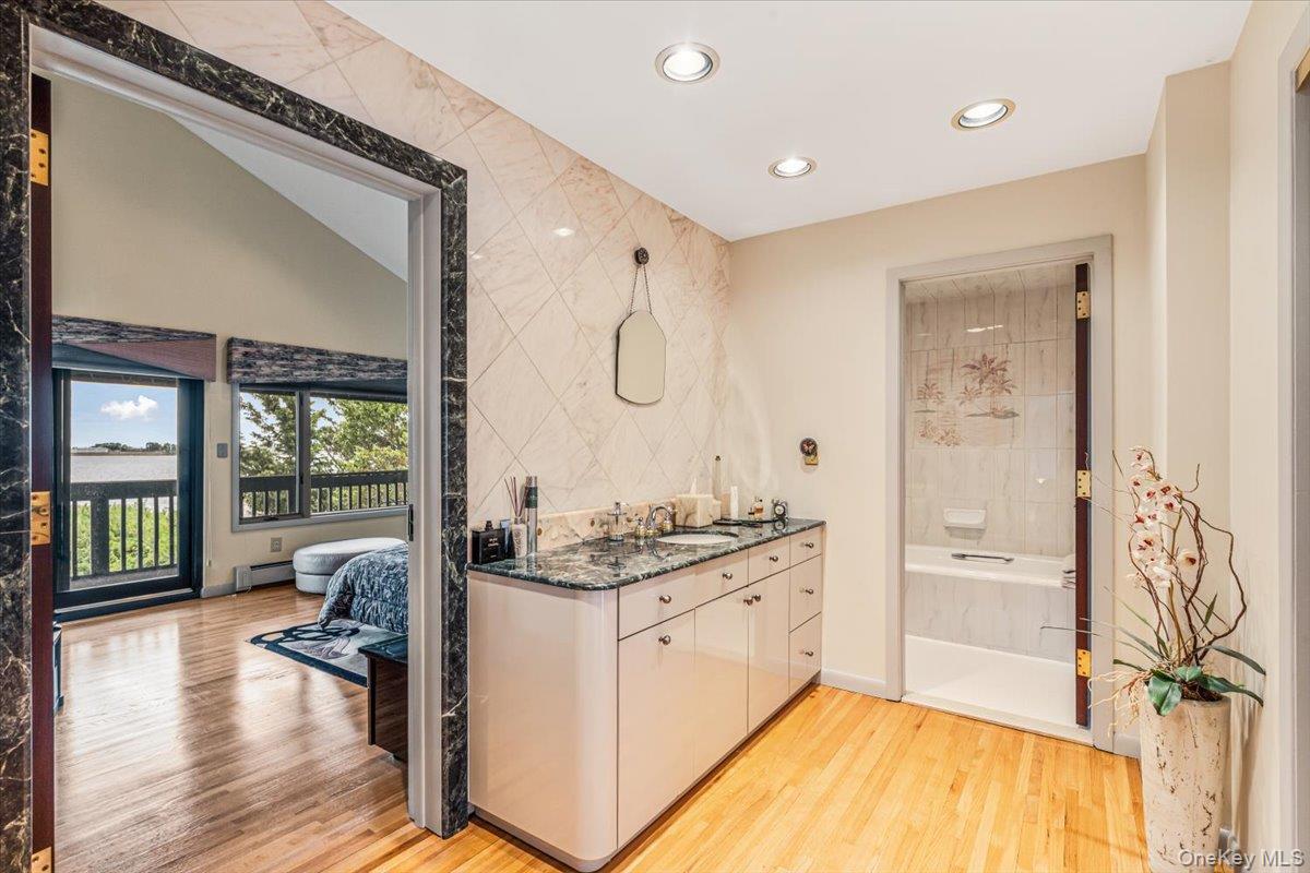 154-43 Riverside Drive Queens, NY 11357 - Photo 27 of 41 a spacious bathroom with a granite countertop tub sink a mirror and a shower