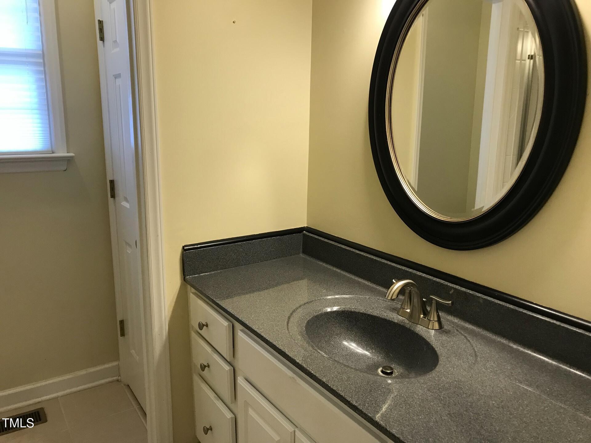 5300 Goldenglow Way Raleigh, NC 27606 - Photo 9 of 24 a bathroom with a sink and a mirror