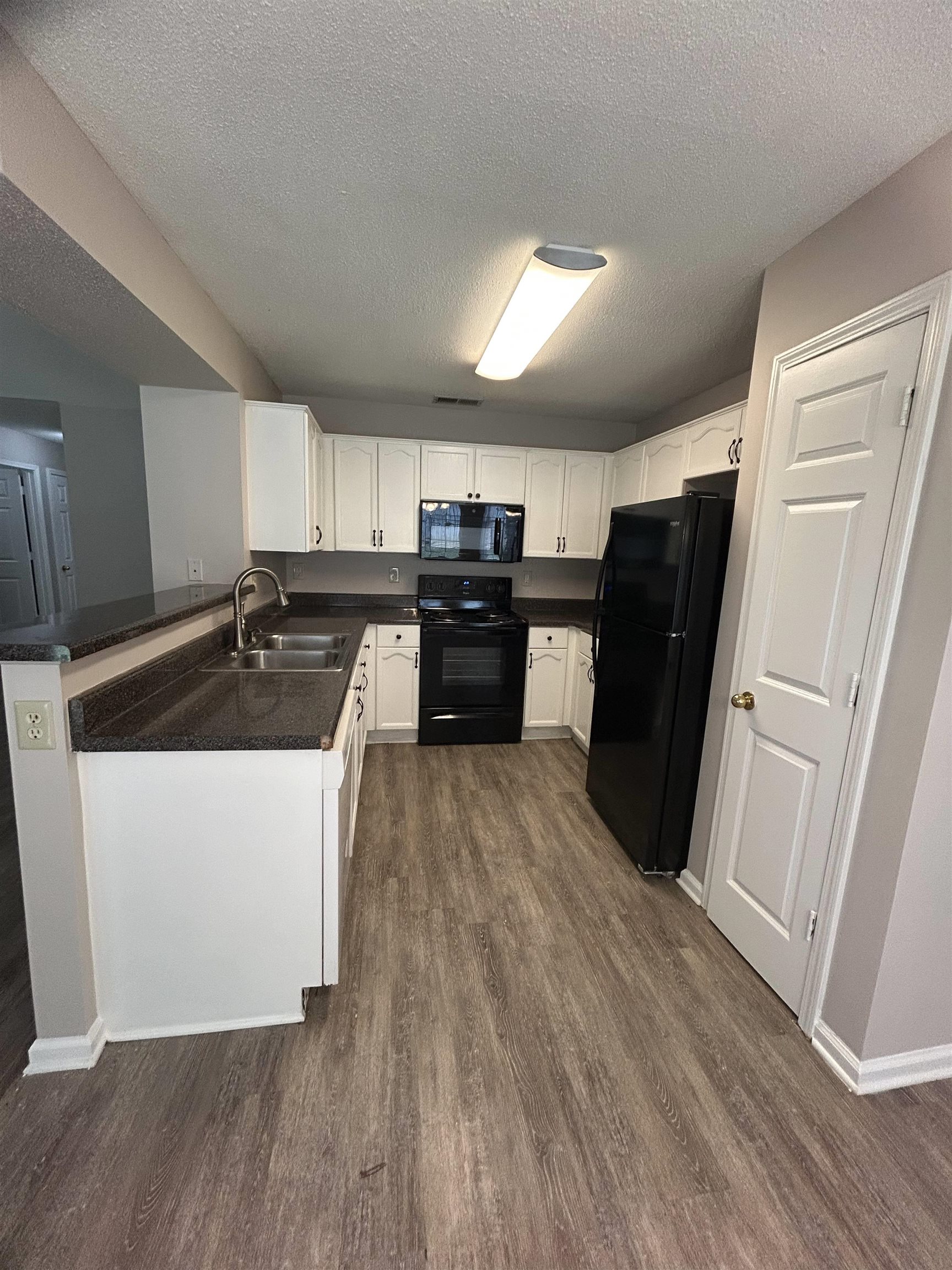 3912 Sundale Way West Memphis, TN 38135 - Photo 8 of 25 a kitchen with a refrigerator a sink and dishwasher with wooden floor