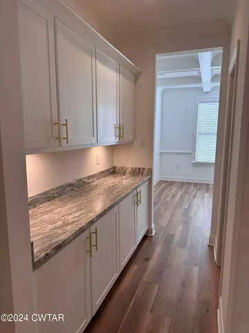a kitchen with granite countertop a sink stove and cabinets