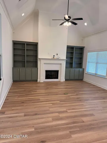 a view of a livingroom with a ceiling fan window and a fireplace
