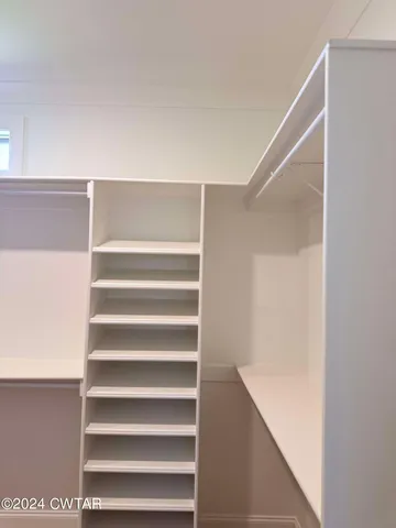 a view of walk in closet with empty racks