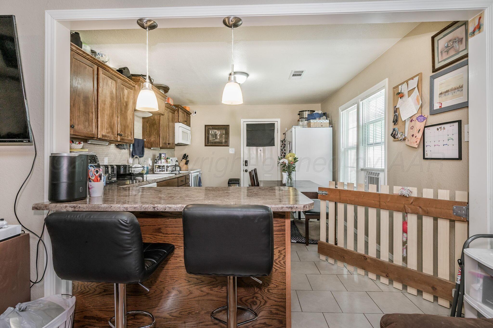 4114 South Hayden Street Amarillo, TX 79110 - Photo 5 of 18 a kitchen with stainless steel appliances kitchen island granite countertop a sink and cabinets