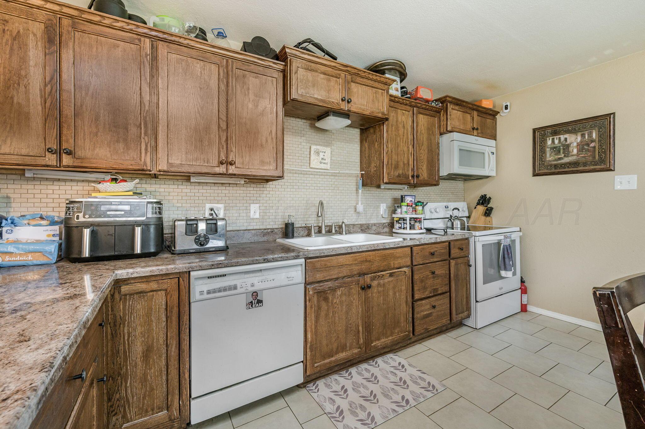 4114 South Hayden Street Amarillo, TX 79110 - Photo 6 of 18 a kitchen with granite countertop a sink stainless steel appliances and cabinets