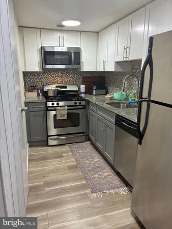 a kitchen with stainless steel appliances granite countertop a sink stove and cabinets