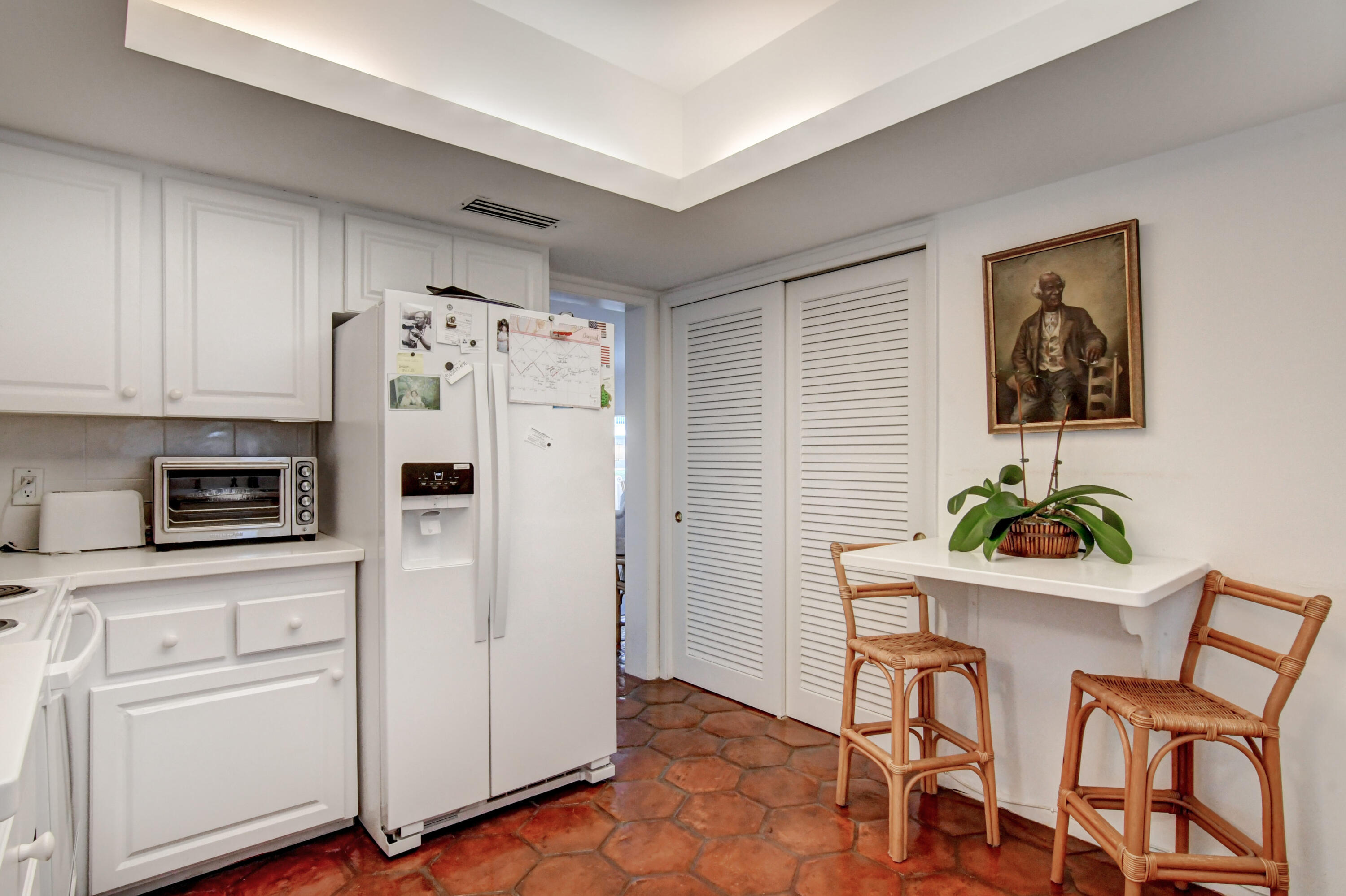 801 North Ocean Boulevard Delray Beach, FL 33483 - Photo 17 of 37 a white kitchen with white cabinets and appliances