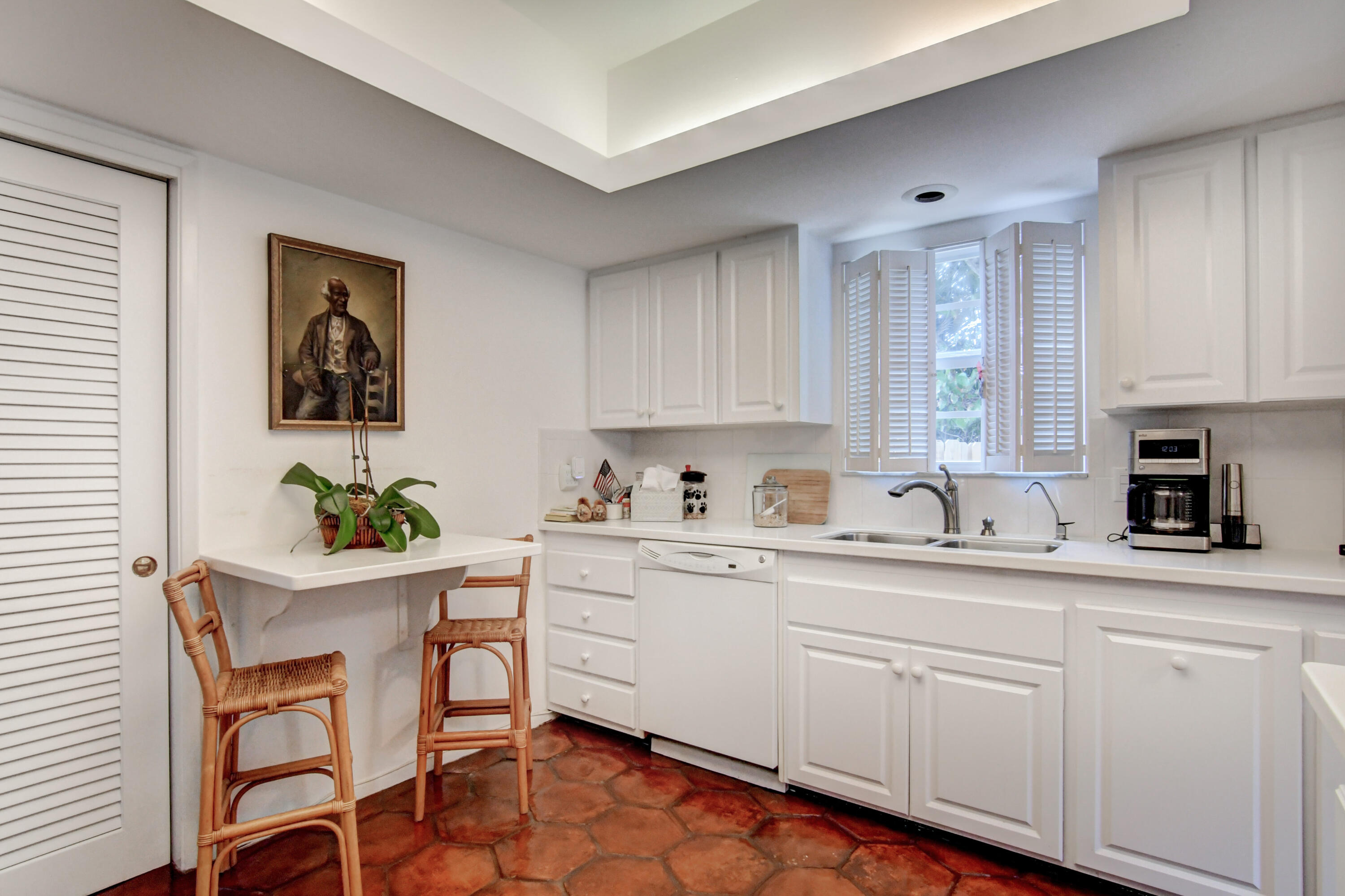 801 North Ocean Boulevard Delray Beach, FL 33483 - Photo 19 of 37 a kitchen with granite countertop white cabinets and white appliances