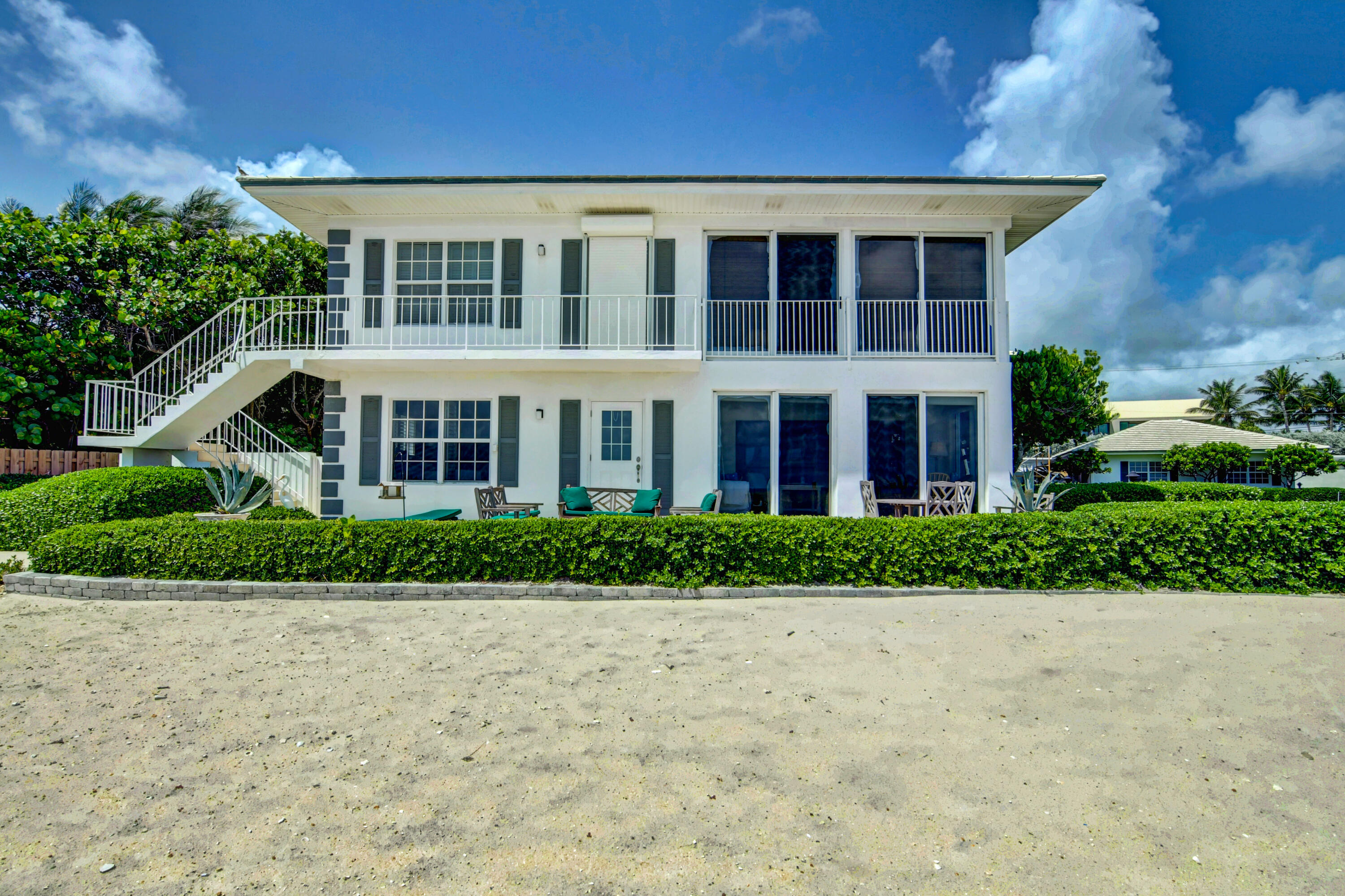801 North Ocean Boulevard Delray Beach, FL 33483 - Photo 24 of 37 a front view of a residential apartment building with a yard