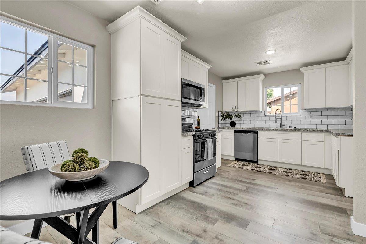 8685 Eddy Street Hanford, CA 93230 - Photo 12 of 45 a kitchen with stainless steel appliances granite countertop a stove a sink a dining table and chairs