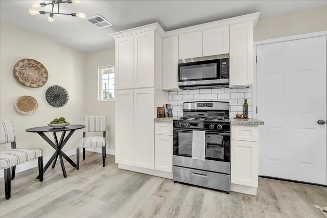 a kitchen with stainless steel appliances granite countertop a sink and cabinets
