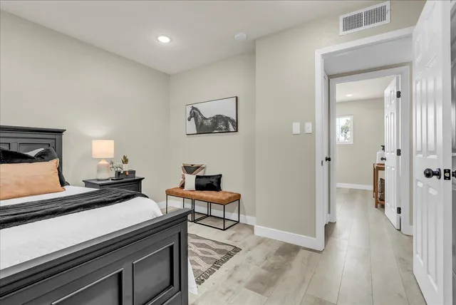 a bedroom with a bed and painting on the wall