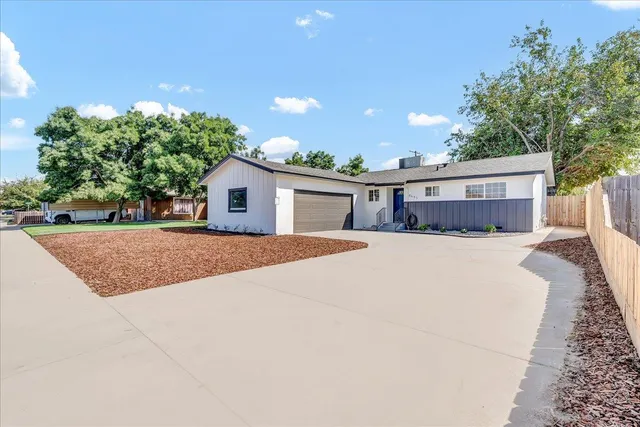 a white house with a yard and parking space