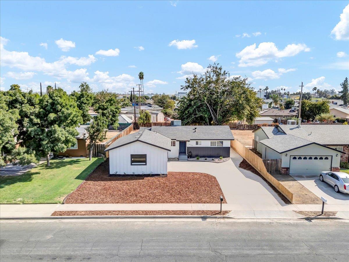 8685 Eddy Street Hanford, CA 93230 - Photo 40 of 45 a white house with a yard and parking space