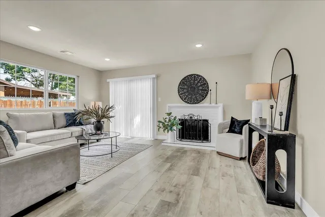 a living room with furniture a fireplace and white walls