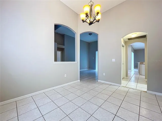 an empty room with a chandelier fan