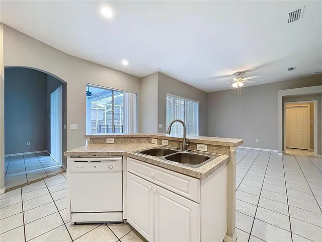an empty room with a chandelier fan and closet area