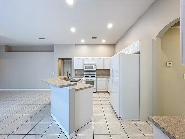 an empty room with a ceiling fan and closet area