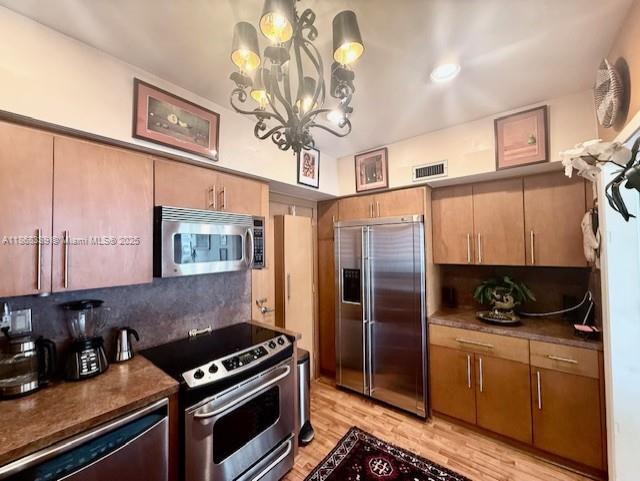1408 Brickell Bay Drive, Unit 303 Miami, FL 33131 - Photo 8 of 24 a kitchen with stainless steel appliances a stove a refrigerator and a sink