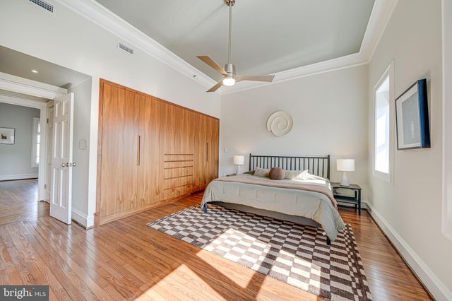 a bedroom with a large bed and a chandelier