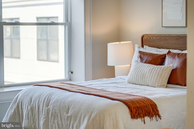a bedroom with a large bed and a chandelier