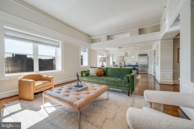 a living room with furniture and floor to ceiling windows