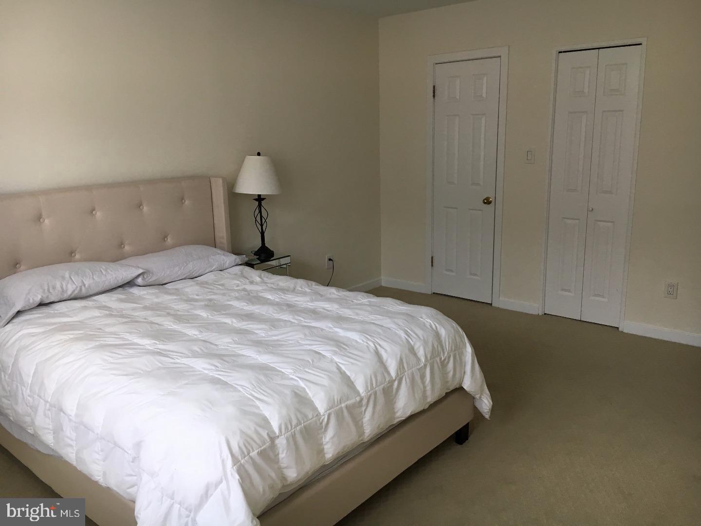 104 Woodside Road, Unit A203 Haverford, PA 19041 - Photo 20 of 22 a large bed sitting in a bedroom and closet