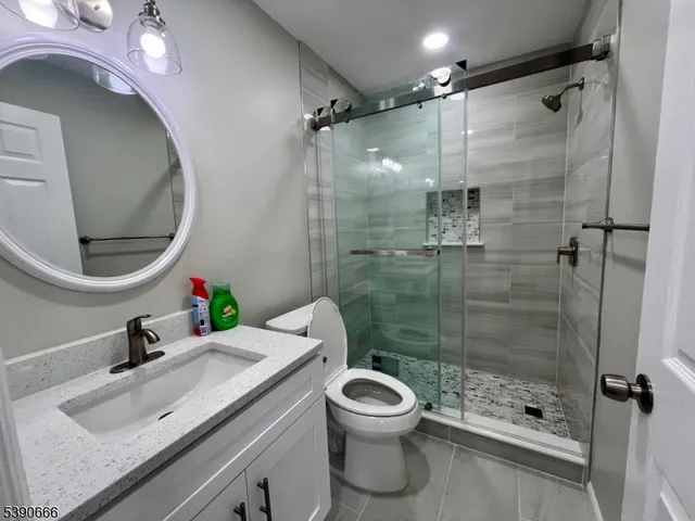 a bathroom with a sink a toilet and shower