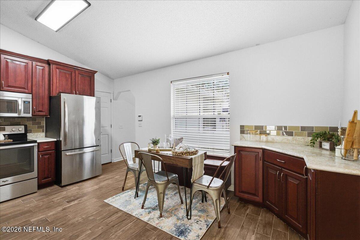 425 3rd Street West Baldwin, FL 32234 - Photo 11 of 47 a view of a dining room with furniture a kitchen and chandelier