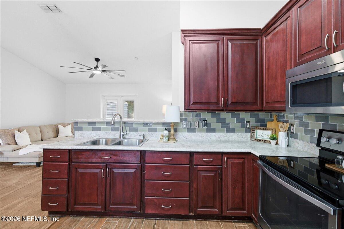 425 3rd Street West Baldwin, FL 32234 - Photo 13 of 47 a kitchen with granite countertop a sink cabinets and stainless steel appliances