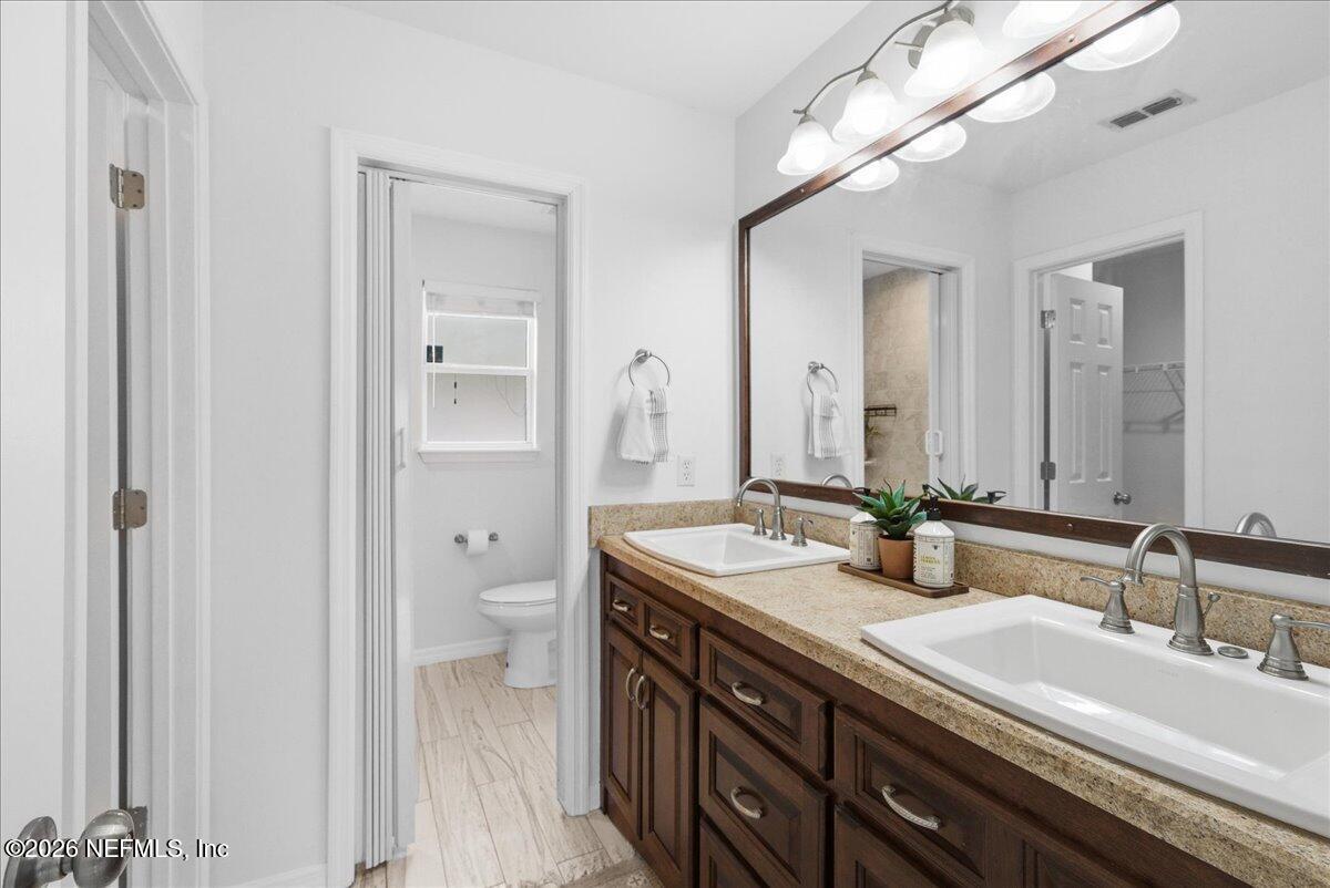 425 3rd Street West Baldwin, FL 32234 - Photo 18 of 47 a bathroom with a granite countertop double vanity sinks and a mirror