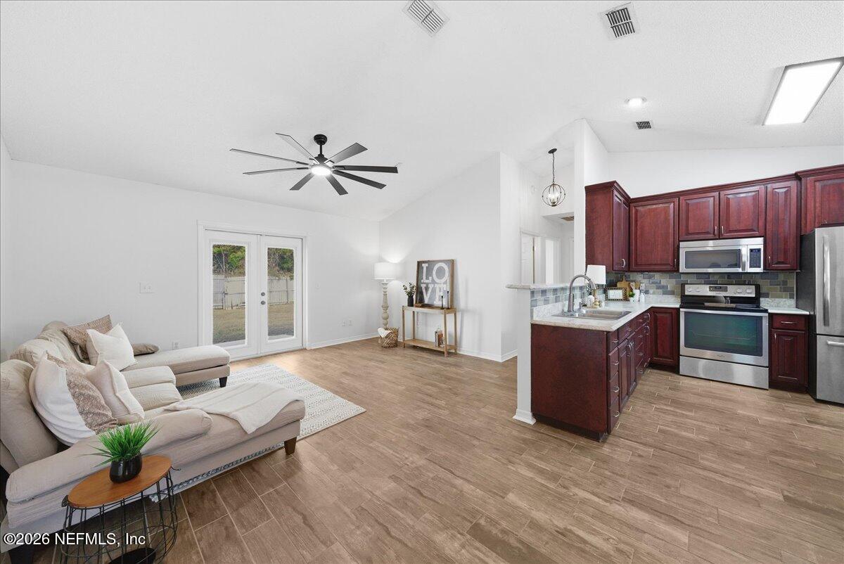 425 3rd Street West Baldwin, FL 32234 - Photo 8 of 47 a living room with stainless steel appliances kitchen island granite countertop furniture and a kitchen view