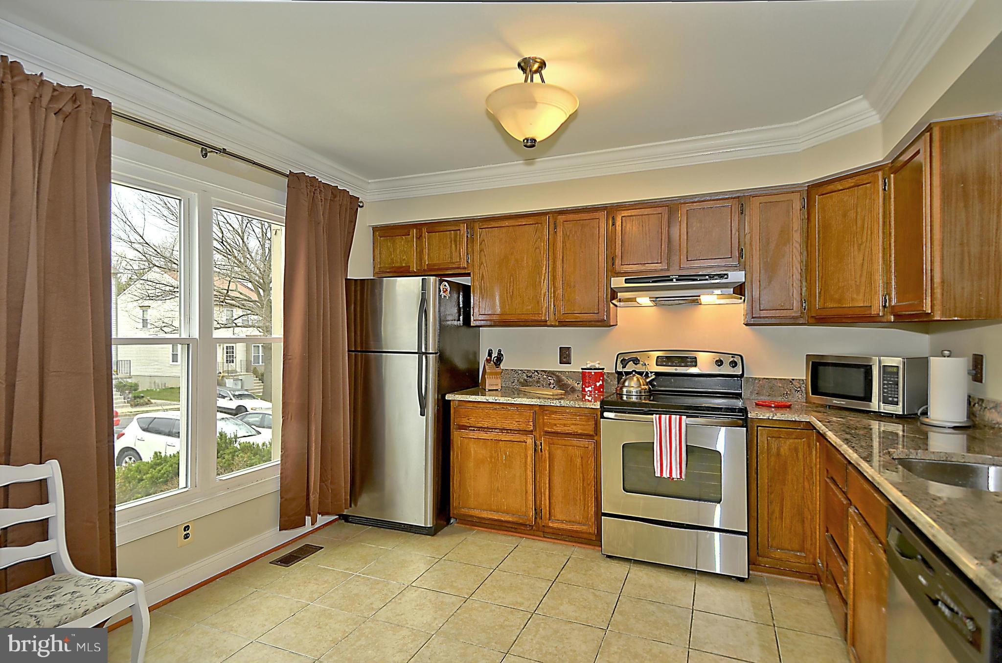 35 Kinsman View Circle Silver Spring, MD 20901 - Photo 3 of 30 a kitchen with stainless steel appliances granite countertop a stove top oven a refrigerator a sink and dishwasher