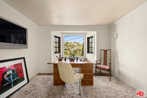 a living room with furniture a window and a flat screen tv