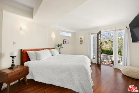 a bed room with a bed window and a flat tv screen