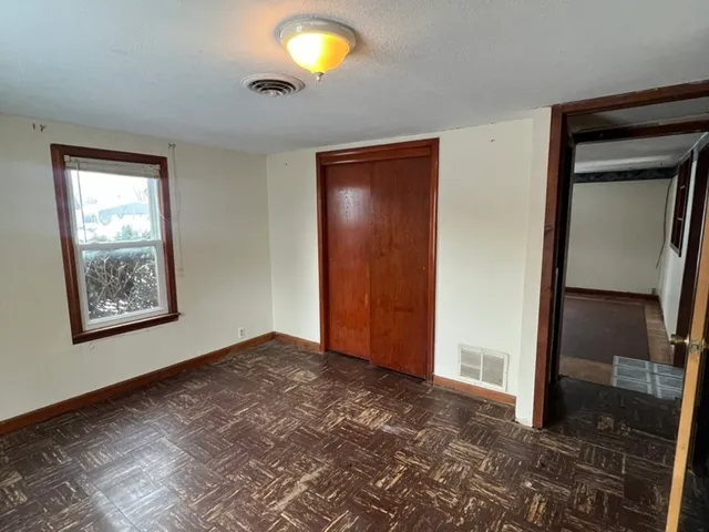 an empty room with windows and closet