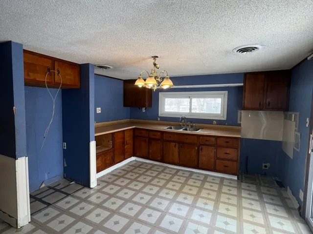 a kitchen with granite countertop a sink and cabinets