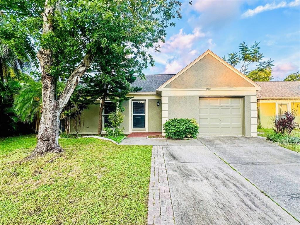 12171 76th Street Largo, FL 33773 - Photo 1 of 1 a front view of a house with a yard and garage